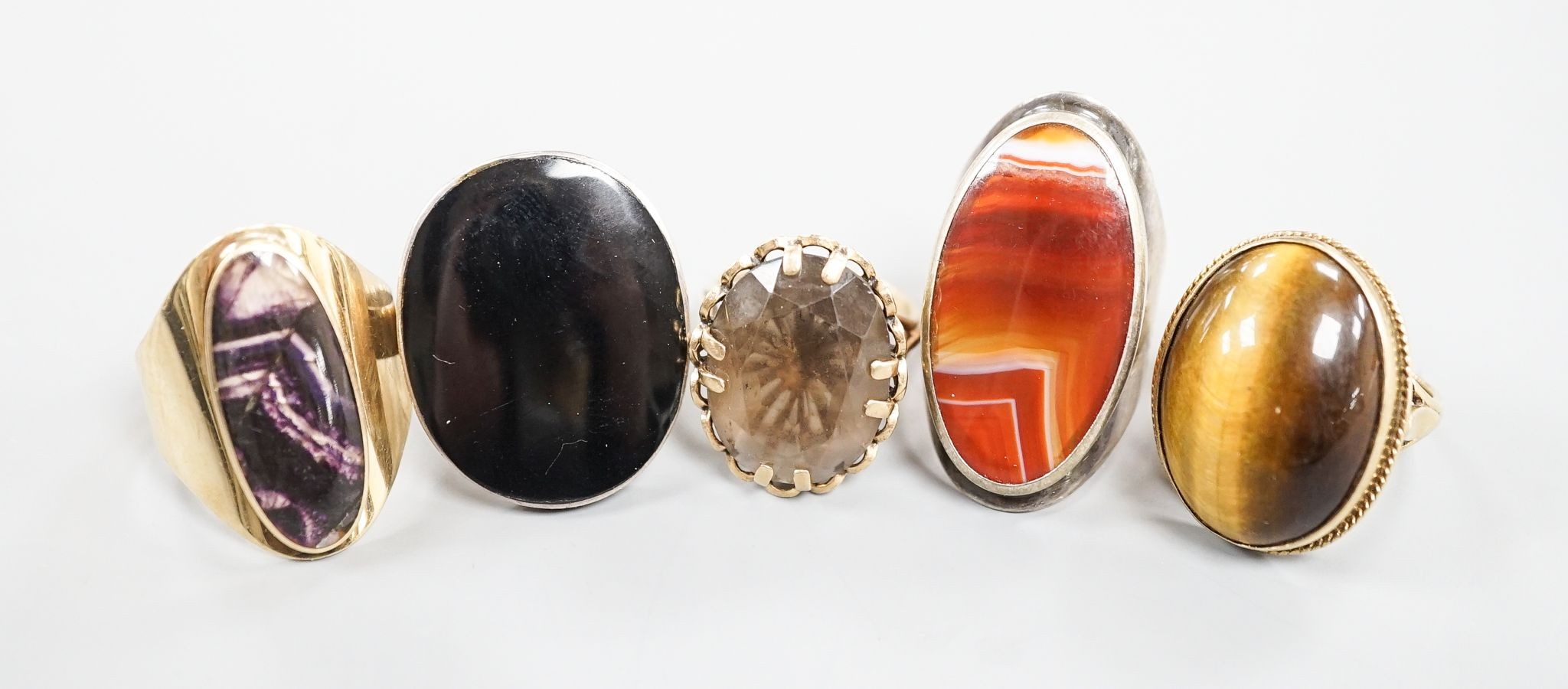 Three assorted 9ct gold and gem set dress rings, including blue john, smoky quartz and tiger's eye quartz, gross 23.9 grams and two white metal and hardstone set dress rings.